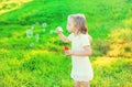 Happy little girl child blowing soap bubbles in summer Royalty Free Stock Photo