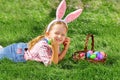 Happy little girl child on the day of Easter is looking for colorful eggs in a basket and folds Royalty Free Stock Photo