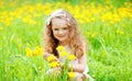 Happy little girl child on grass with yellow dandelion flowers in summer Royalty Free Stock Photo