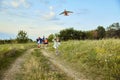 Happy little girl, child running with kite on trail in field. Spending time with parents and sister outdoors on warm Royalty Free Stock Photo