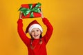 Happy little girl with christmas present. The child holds a box over his head Royalty Free Stock Photo