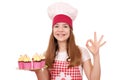 Little girl cook with muffins and ok hand sign Royalty Free Stock Photo