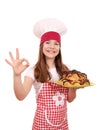 Little girl cook with tasty croissant and ok hand sign