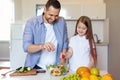 Happy Little Girl Cooking With Daddy Preparing Salad In Kitchen Royalty Free Stock Photo