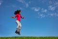 Happy curly hair girl jump over blue sky side view Royalty Free Stock Photo