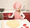 Happy little girl cuts dough with form for cookies Royalty Free Stock Photo