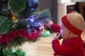 Happy little girl decorating the christmas tree at home. Winter holidays and people concept. Christmas tree. New Year`s holidays.