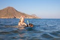 Happy little girl with diving glasses on back of woman snorkeling in the water of a beach in Andalusia Royalty Free Stock Photo