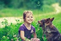 Happy  little girl with dog on the clover lawn Royalty Free Stock Photo