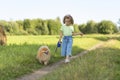 Happy little girl with dog running in park, summer field. child playing with puppy outdoors. Royalty Free Stock Photo