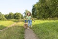 Happy little girl with dog running in park, summer field. child playing with puppy outdoors. Royalty Free Stock Photo