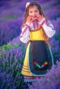 Happy little girl with dress enjoying lavender field with bouquet of flowers Royalty Free Stock Photo