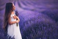 Happy little girl with dress enjoying lavender field with bouquet of flowers Royalty Free Stock Photo