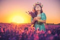 Happy little girl with dress enjoying lavender field with bouquet of flowers Royalty Free Stock Photo