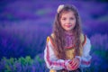 Happy little girl with dress enjoying lavender field with bouquet of flowers Royalty Free Stock Photo