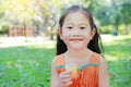 Happy of little girl drinking Orange juice with stained around her mouth in the summer garden Royalty Free Stock Photo
