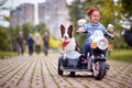 Happy little girl driving in a toy motocycle