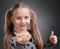 Happy little girl eating bread and butter with fish