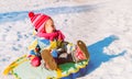 Happy little girl enjoy snow ride, winter kids activities Royalty Free Stock Photo