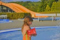 Happy little girl enjoying summer day in the swimming pool. Cute girl with inflatable armbands in small swimming pool. Summer and Royalty Free Stock Photo