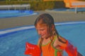 Happy little girl enjoying summer day in the swimming pool. Cute girl with inflatable armbands in small swimming pool. Summer and Royalty Free Stock Photo