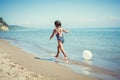 Happy little girl enjoying sunny day at the beach. With a ballon Royalty Free Stock Photo