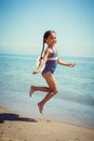 Happy little girl enjoying sunny day at the beach.Jumping Royalty Free Stock Photo