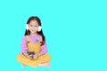 Happy little girl enjoys listening to music with headphones isolated on cyan background with copy space Royalty Free Stock Photo
