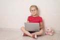 Happy little girl in eyeglasses using notebook laptop sitting on the floor at home. Vision school education homeschooling e- Royalty Free Stock Photo