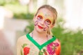 Happy little girl with face art paint in the park. Royalty Free Stock Photo