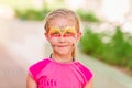 Happy little girl with face art paint in the park. Royalty Free Stock Photo