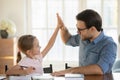 Happy little girl and father giving high five, studying together Royalty Free Stock Photo