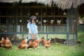 Happy little girl feeding chickens in front of chicken farm. Royalty Free Stock Photo