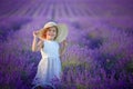 A happy little girl in a field holding a basket with lavender flowers Royalty Free Stock Photo