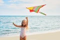 Happy little girl with flying kite on tropical beach Royalty Free Stock Photo