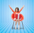 Happy little girl with gift boxes sitting on chair Royalty Free Stock Photo