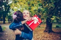 Happy little girl gives her friend a gift in a red box, making a surprise Royalty Free Stock Photo