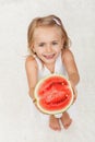 Happy little girl giving you half of a watermelon Royalty Free Stock Photo