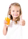 Happy little girl with glass of juice and finger up Royalty Free Stock Photo
