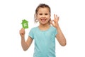 happy little girl with green house icon showing ok Royalty Free Stock Photo