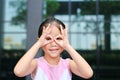 Happy little girl with hands glasses in front of her eyes