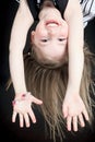 Happy little girl hanging upside down isolated on Royalty Free Stock Photo