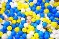 Happy little girl having fun in ball pit in kids indoor play center. Child playing with colorful balls in playground ball pool.