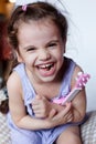 Happy little girl having fun playing with toy guitar or ukulele. Royalty Free Stock Photo