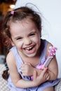 Happy little girl having fun playing with toy guitar or ukulele. Royalty Free Stock Photo