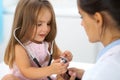 Happy little girl at health exam at doctor office. Medicine and health care concept Royalty Free Stock Photo