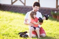 Happy little girl and her father lifting dumbbells outdoors