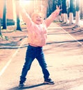 Happy little girl with her hands up outdoors. Freedom and carefree. Happy childhood. retro haze toned