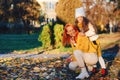 Happy little girl and her mother playing in the autumn park. Lovely family laughing on autumn walk Royalty Free Stock Photo