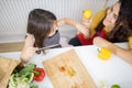 Little girl and her mother slicing vegetables on a cutting board Royalty Free Stock Photo